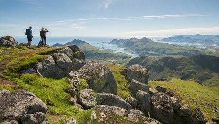 Wanderer genießen die Aussicht auf die norwegischen Fjorde vom Berggipfel Justadtinden auf den Lofoten