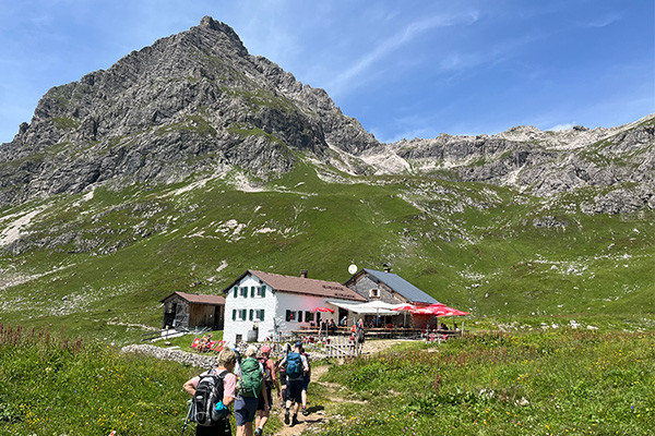 Wandergruppe vor Hütte bei der Alpenüberquerung von Oberstdorf nach Meran